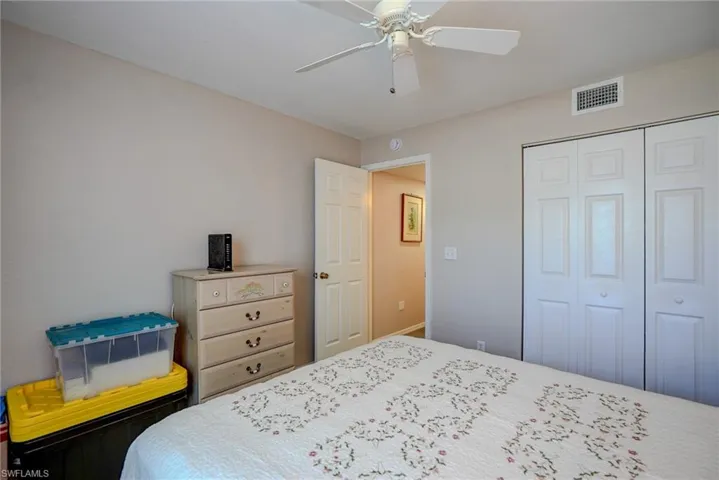 Bedroom with a closet, visible vents, and a ceiling fan