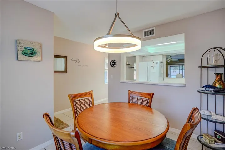 Dining space with ceiling fan, baseboards, visible vents, and light tile patterned floors