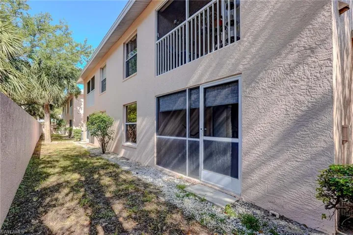 View of side of property featuring fence and stucco siding
