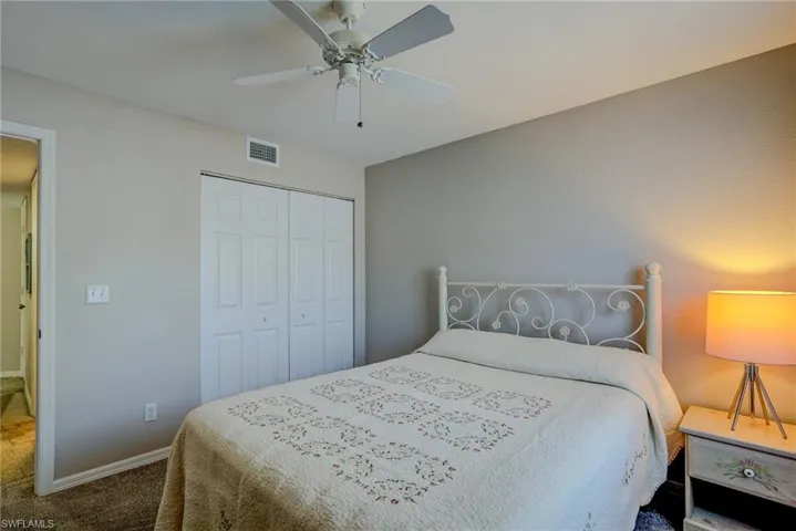 Carpeted bedroom featuring baseboards, a ceiling fan, visible vents, and a closet
