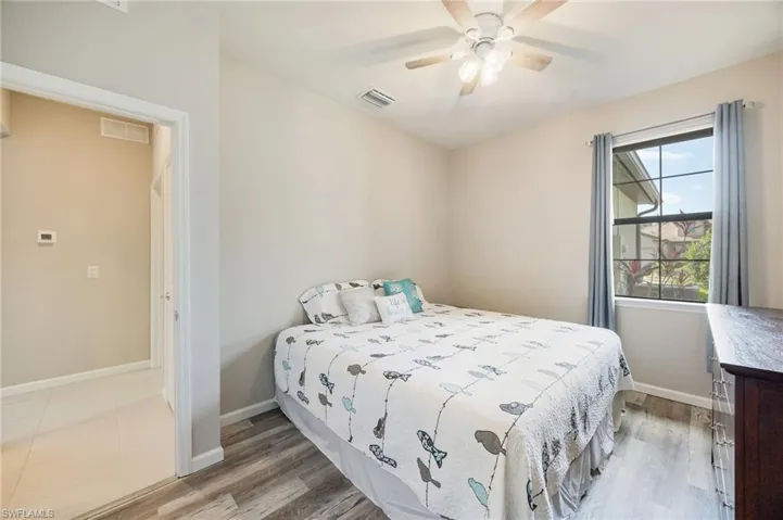 Bedroom featuring light wood-style floors and ensuite bath