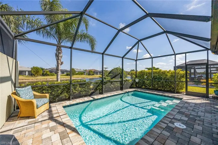 Outdoor pool featuring a sunroom, a lanai, a water view, and a patio area