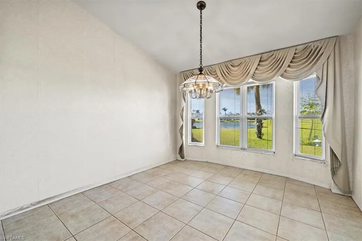 Unfurnished dining area with a notable chandelier and light tile patterned floors