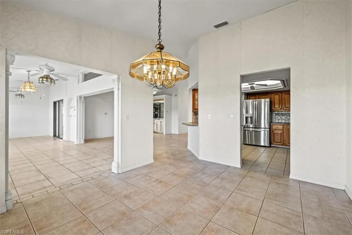 Unfurnished dining area with a chandelier and light tile patterned floors