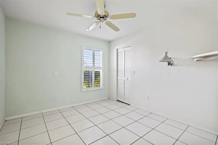 Unfurnished room with light tile patterned floors and ceiling fan