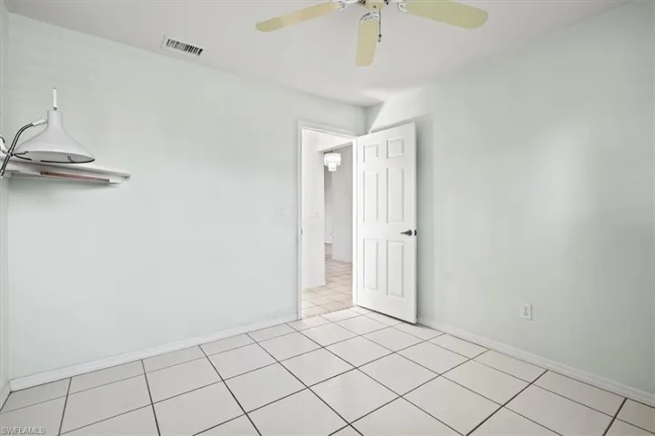Spare room featuring ceiling fan and light tile patterned flooring