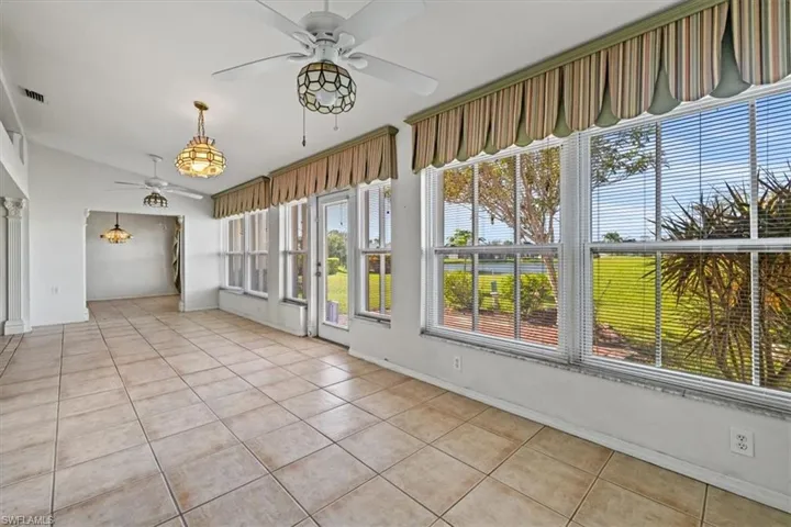 Unfurnished sunroom with lofted ceiling and ceiling fan