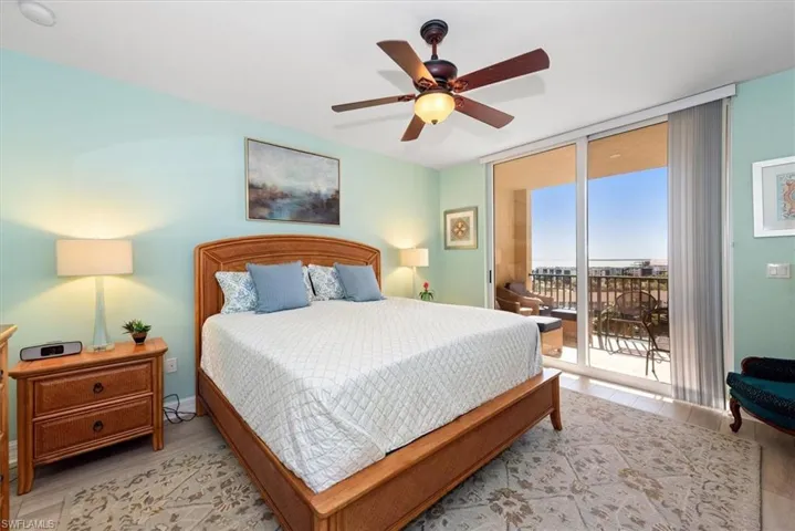 Bedroom with floor to ceiling windows, ceiling fan, wood finished floors, and access to outside