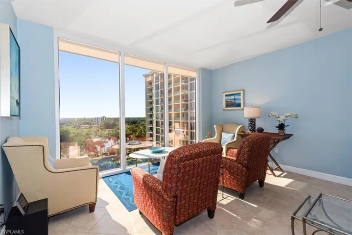 Sitting room featuring floor to ceiling windows, a ceiling fan, and tile patterned floors