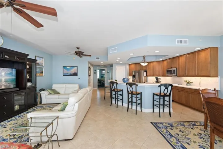 Living area with ceiling fan, recessed lighting, and light tile patterned floors