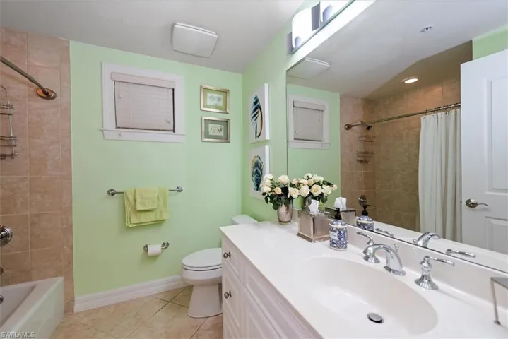 Full bathroom featuring vanity, shower / tub combo with curtain, and light tile patterned floors