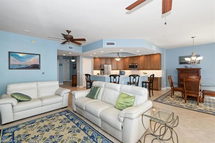 Living area with ceiling fan, light tile patterned floors, and hanging lights