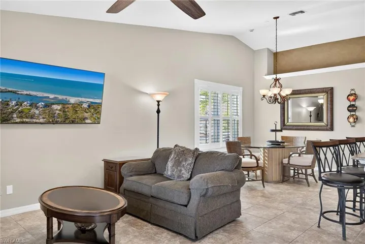 Living area featuring lofted ceiling, a chandelier, and ceiling fan