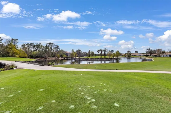 View of home's community with a water view, a yard, and golf course view