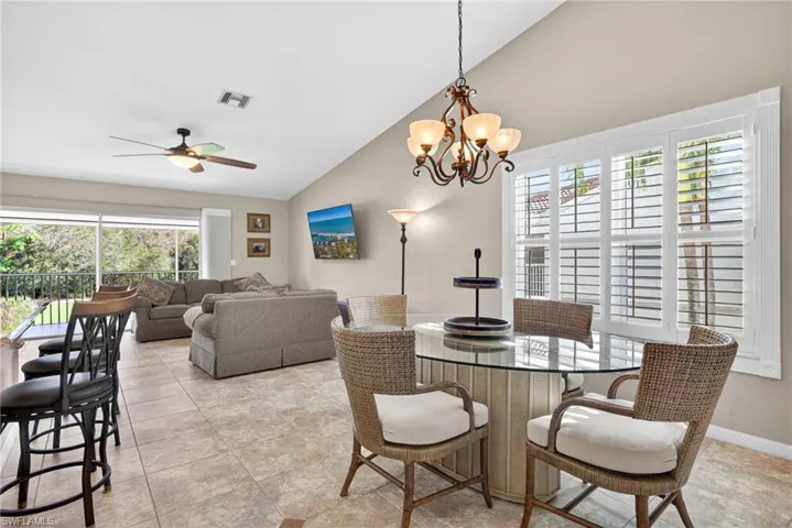 Dining room featuring vaulted ceiling, a chandelier, and ceiling fan
