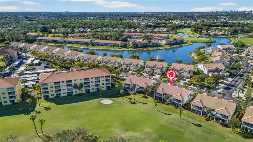 Aerial view of property and surrounding area featuring a nearby body of water and a golf club