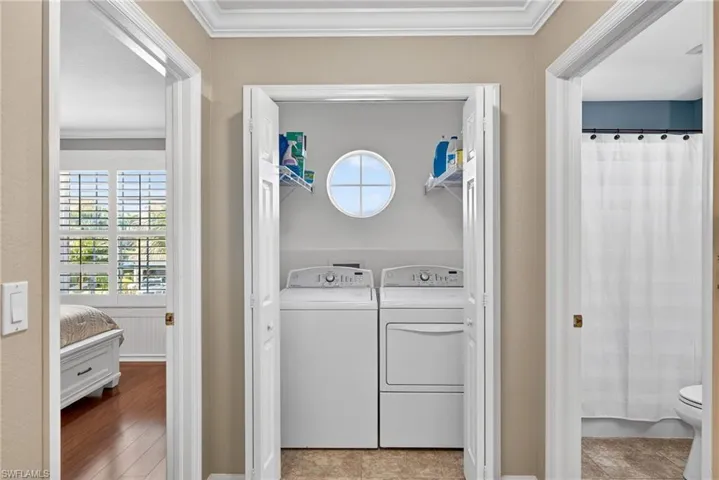 Laundry room featuring ornamental molding and washer and dryer