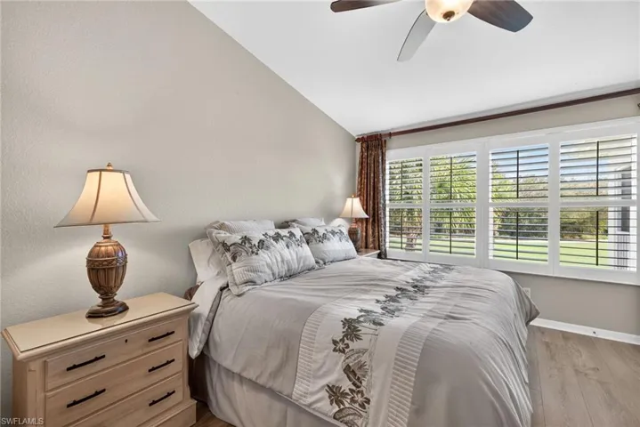 Bedroom with vaulted ceiling, ceiling fan, and light wood finished floors