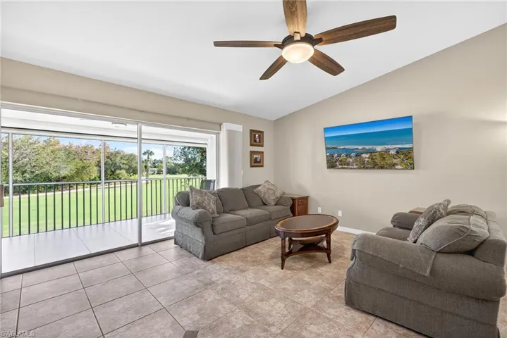Living area featuring vaulted ceiling, a ceiling fan, and tile patterned flooring