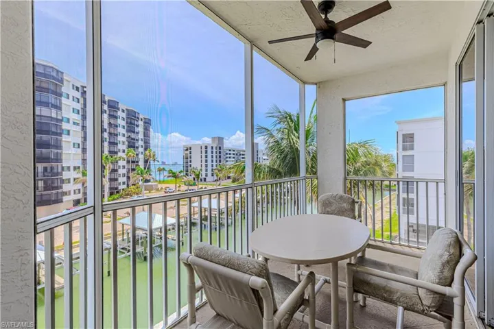 Sunroom with floor to ceiling windows, a view of city, a ceiling fan, and a textured wall