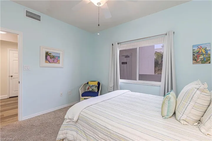 Carpeted bedroom featuring baseboards, visible vents, and a ceiling fan