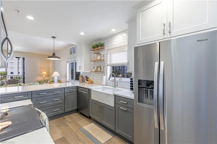 Kitchen featuring gray cabinetry, decorative backsplash, appliances with stainless steel finishes, and a sink