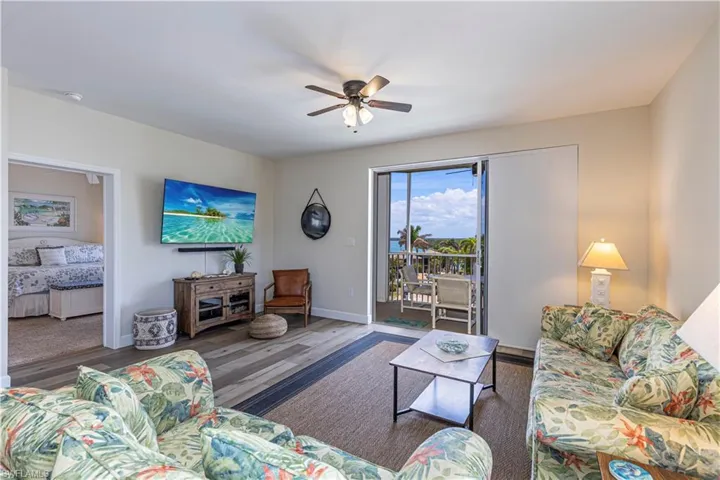 Living room with a ceiling fan, baseboards, and wood finished floors