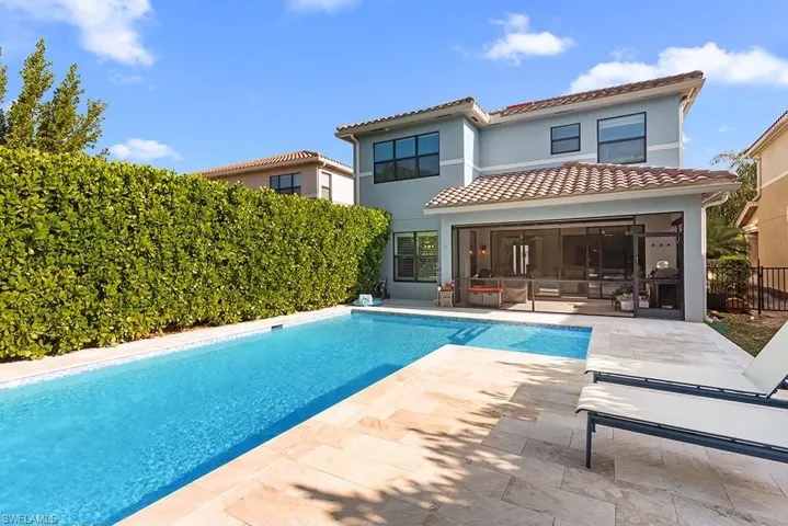Back of property with a fenced in pool and a patio