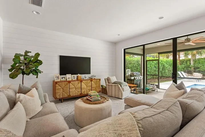 Living room with ceiling fan and wood walls
