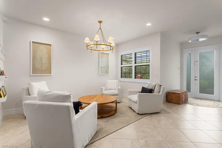 Tiled living room featuring a chandelier