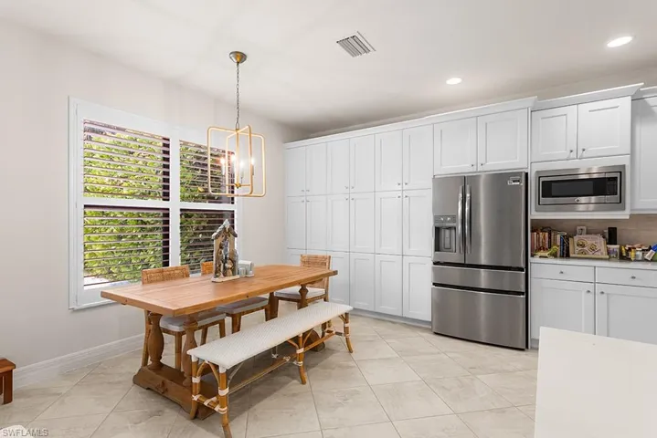 Tiled dining area featuring a wealth of natural light and a chandelier