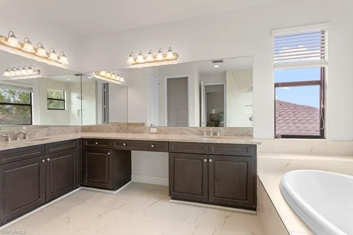 Bathroom featuring tiled bath and vanity