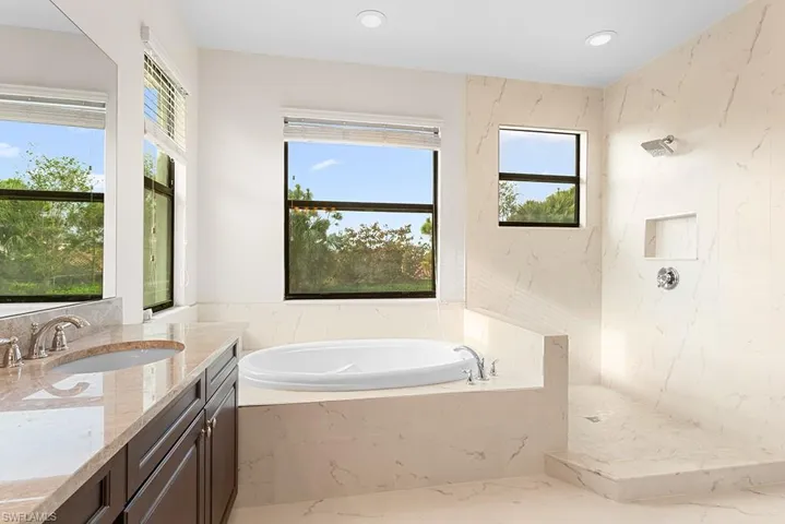Bathroom featuring plus walk in shower and vanity