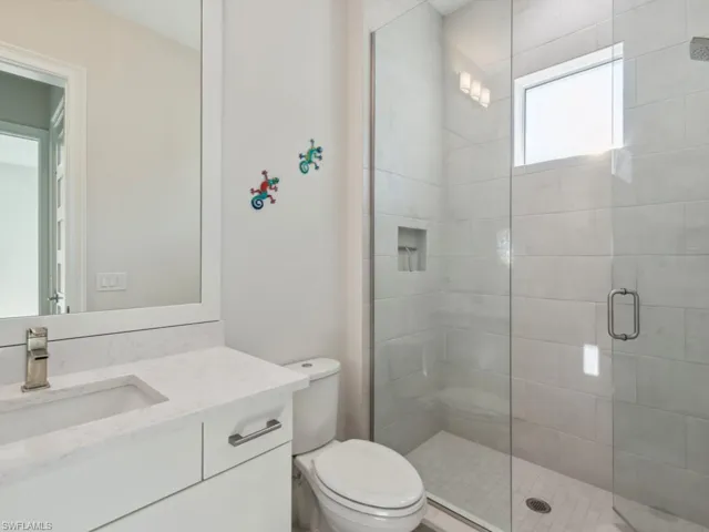 Bathroom with vanity, toilet, and a shower with door