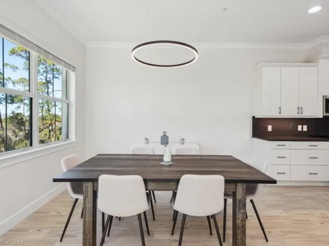 Dining area featuring light wood-style floors and crown molding