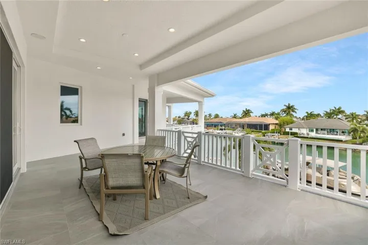 View of patio / terrace with outdoor dining space, a residential view, and a water view