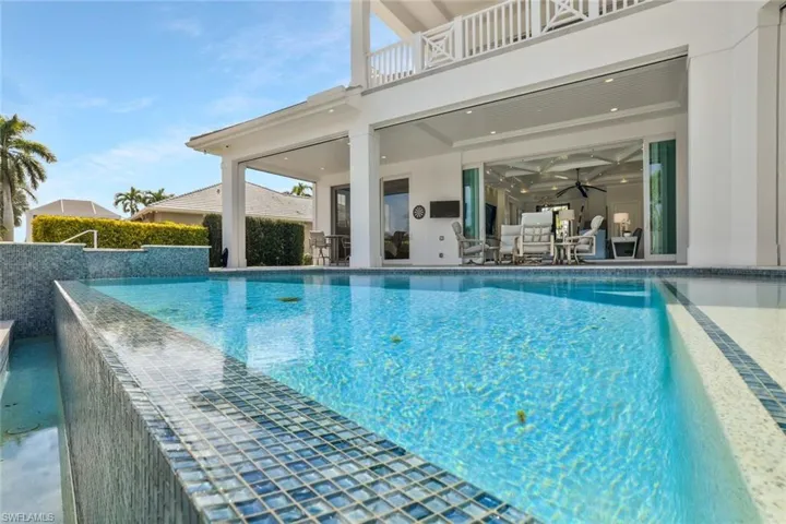 View of swimming pool featuring an infinity pool, patio surround, and a balcony