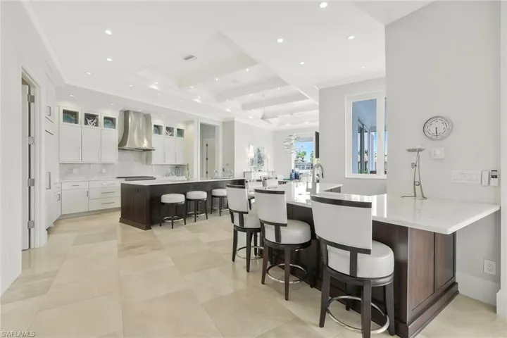 Kitchen featuring a breakfast bar area, recessed lighting, light stone countertops, a peninsula, and backsplash