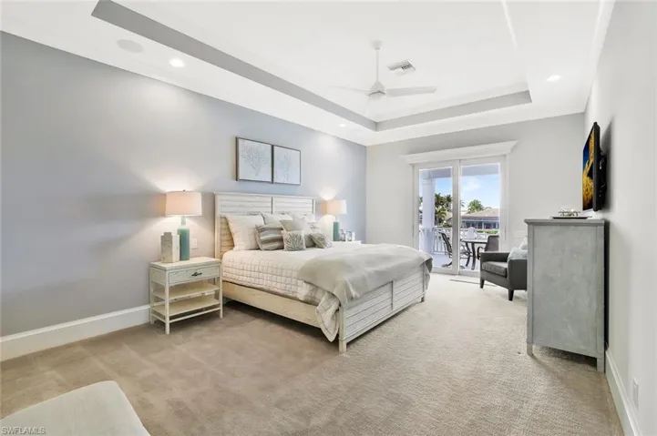 Bedroom with access to exterior, light colored carpet, ceiling fan, and recessed lighting