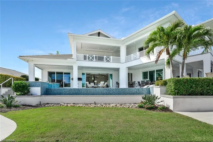 Back of property featuring a patio, stucco siding, a yard, and a balcony