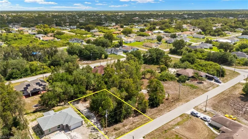 Aerial view of residential area featuring property parcel outlined and a tree filled landscape