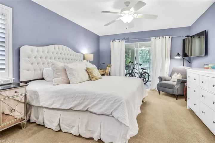 Bedroom featuring light carpet, access to exterior, and a ceiling fan