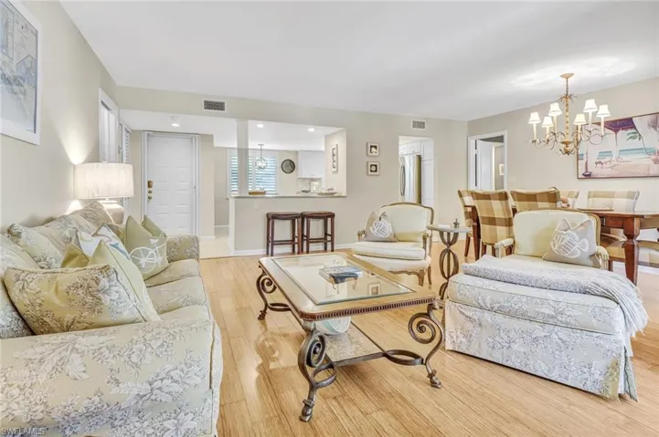 Living room with light wood-style flooring and hanging lights