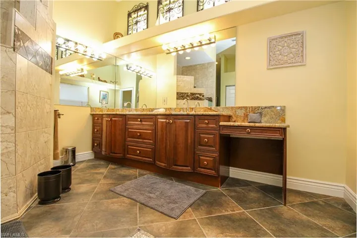 Bathroom with tile walls, a towering ceiling, and vanity