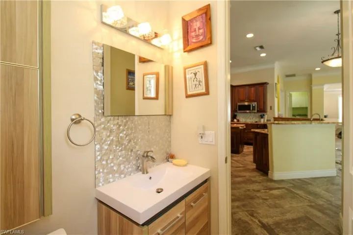 Bathroom featuring backsplash, vanity, and ornamental molding