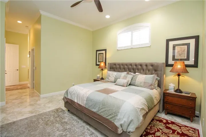 Bedroom with ornamental molding and ceiling fan