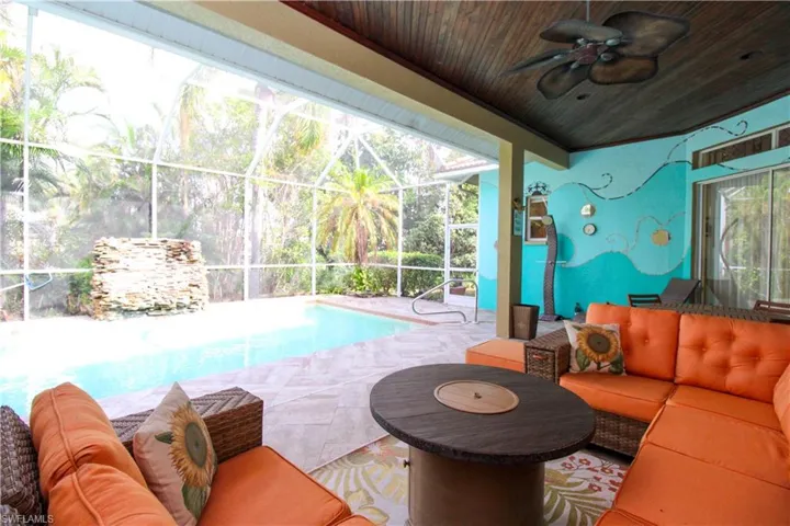 View of swimming pool with a patio area, glass enclosure, outdoor lounge area, and ceiling fan