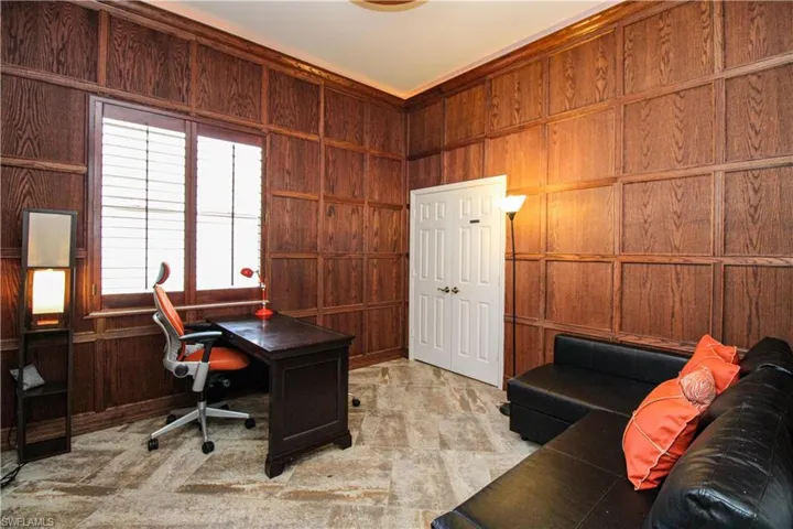 Office with wood walls and light colored carpet