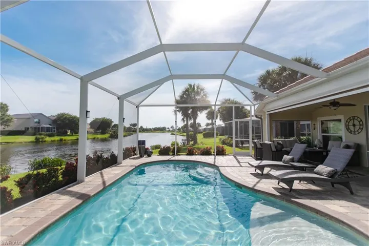 View of swimming pool with a patio, a lanai, a water view, and ceiling fan