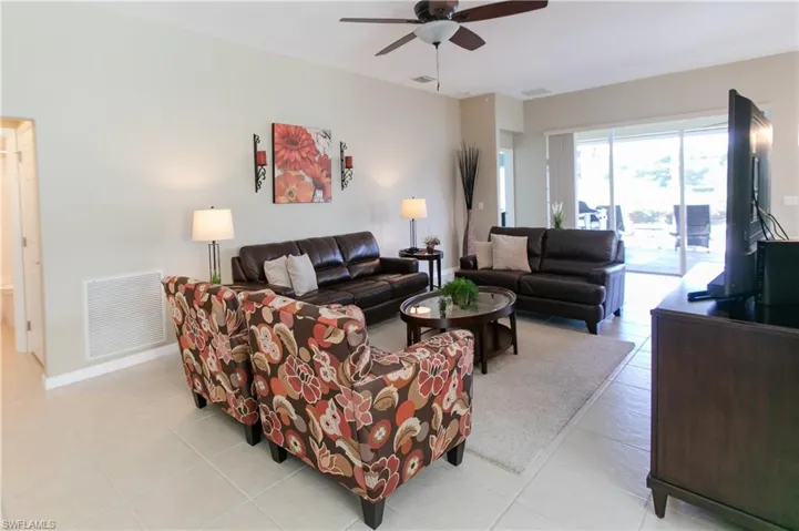 Living room featuring ceiling fan and light tile floors